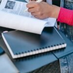 student sitting at table and studying text in daytime